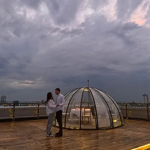 Романтический ужин при свете ночного неба на крыше города в окружении облаков