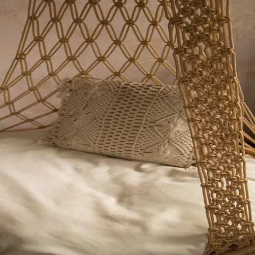 Уютное кресло-гамак с декоративной подушкой в интерьере домашнего пространства