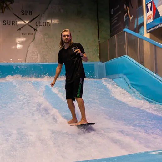 Сёрфер катается на волнорезе в СПБ, наслаждаясь спортом в любое время года