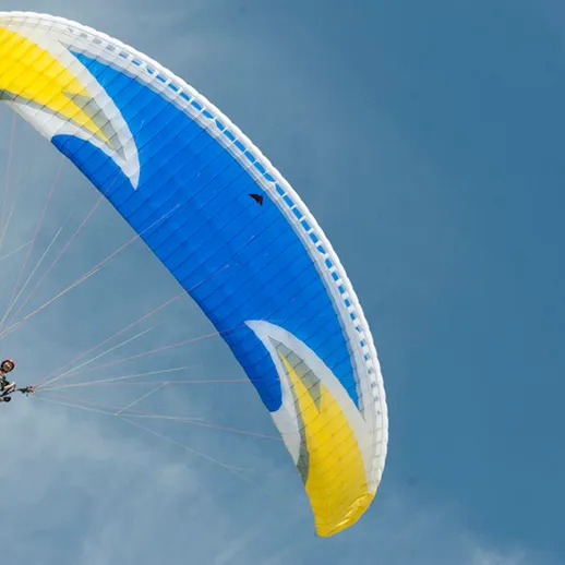 Парапланерист в небе над живописным ландшафтом в солнечный день