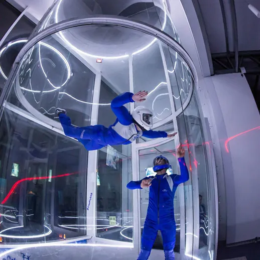 Тренировка в футуристическом аэродинамическом туннеле в темное время суток с инструктором