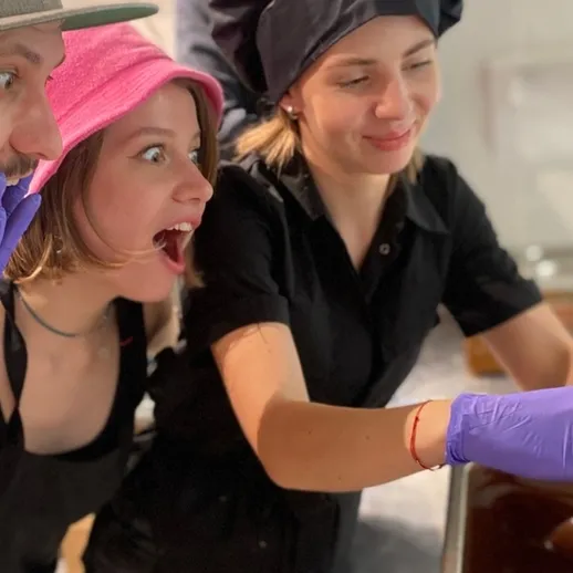 Участники кулинарного мастер-класса удивляются результатам своей работы на занятии в кулинарной школе