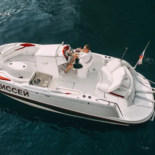 Человек управляет моторной лодкой на воде в ясный день