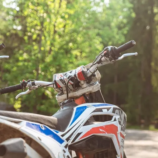 Внедорожные мотоциклы на парковке в лесу в солнечный день