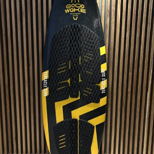 Доска для вейкбординга с ярким дизайном и текстурированной поверхностью в студии на фоне деревянной стенки