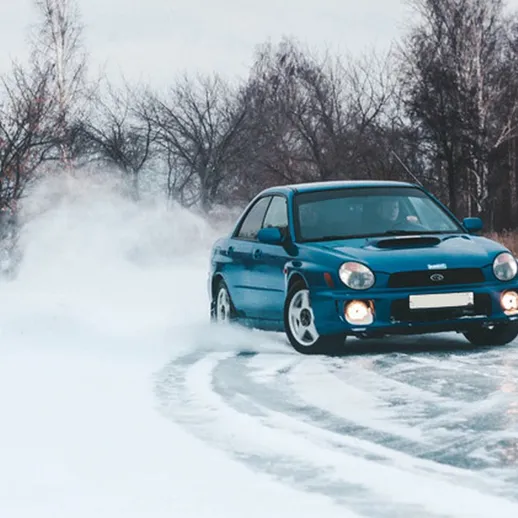 Автомобиль на льду выполняет дрифт в зимний день в лесу