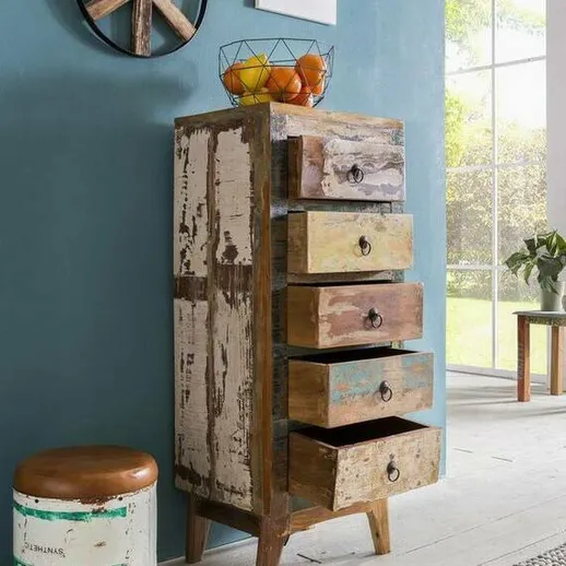 Комод из дерева с пятью ящиками в современном интерьере квартиры с яркой стеной и натуральным светом