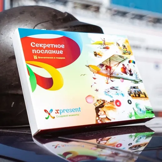 Уникальный подарок на столе с картинками и яркими цветами на фоне строительного объекта в солнечный день