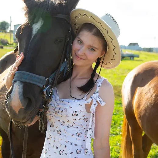 Молодая женщина обнимает лошадь на ферме в солнечный день, наслаждаясь природой и животными в России