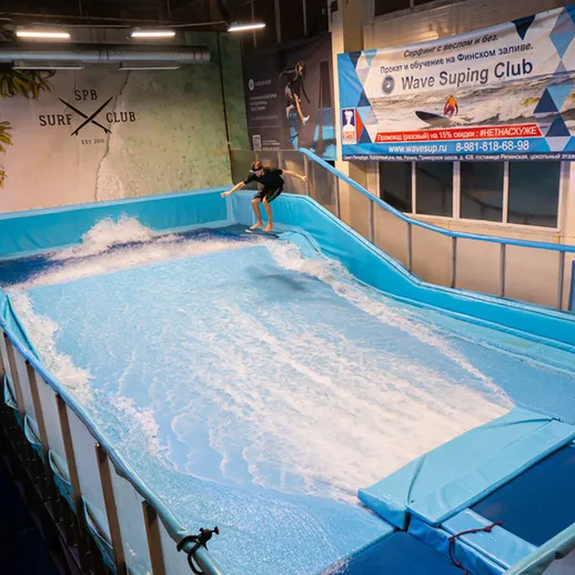 Серфинг на искусственной волне в клубе во время вечернего занятия в Санкт-Петербурге