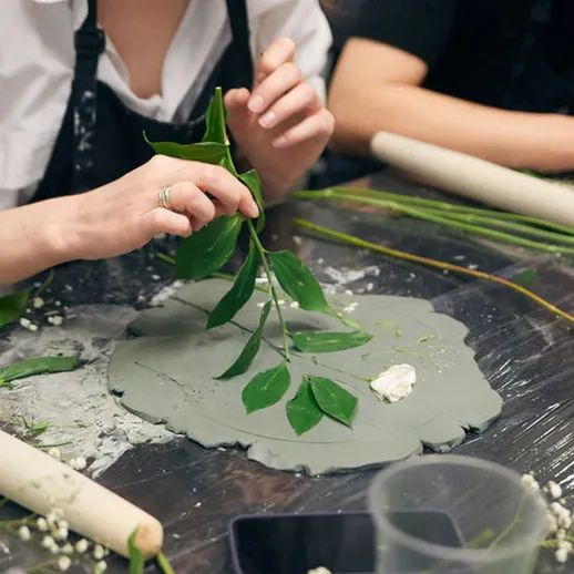 Создание глиняных изделий с использованием зелени в мастерской, где проходит обучение навыкам ручной работы