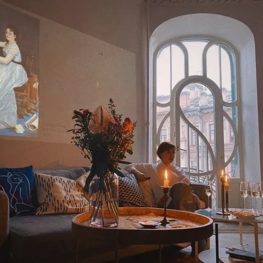 Уютная комната с вечерним освещением и проекцией художественного произведения на стене