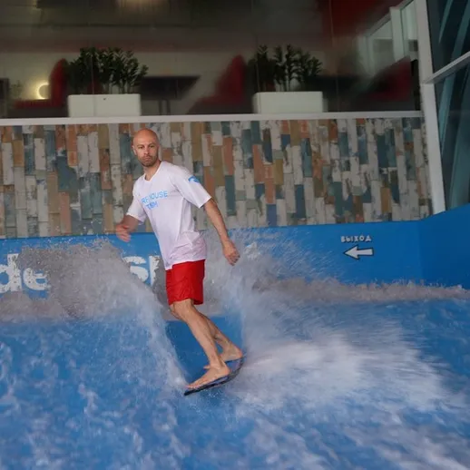 Кайтсерфер наслаждается волнением на симуляторе серфинга в крытом аквапарке