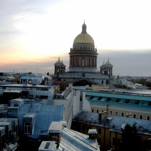 Вид на Исаакиевский собор в Санкт-Петербурге на фоне заката с крыш зданий