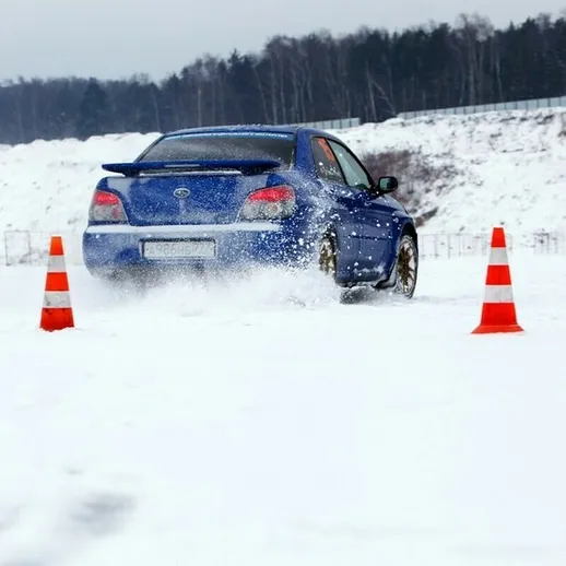 Зимние испытания автомобиля на снежной трассе с конусами, экстремальные условия и наклонные повороты