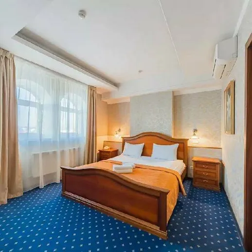 Уютный номер в гостинице с двумя кроватями и большими окнами в светлом интерьере