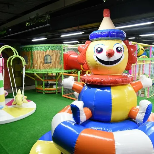 Игровая площадка с надувным клоуном и аттракционами для детей в развлекательном центре
