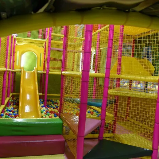 Яркая игровая площадка для детей с горкой и шариками в помещении для развлечений
