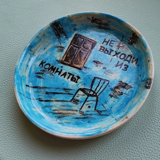 Керамическая тарелка с надписью Не выходи из комнаты и изображением двери и стула на голубом фоне