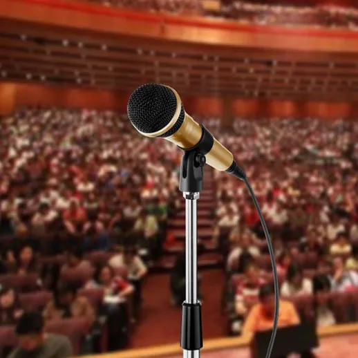 Микрофон на сцене перед многотысячной аудиторией во время важного события в концертном зале