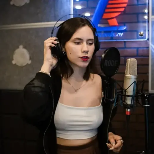 Молодая певица записывает музыку в студии звукозаписи