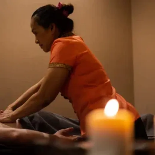 Массажный сеанс с профессиональным терапевтом в расслабляющей атмосфере на фоне свечей