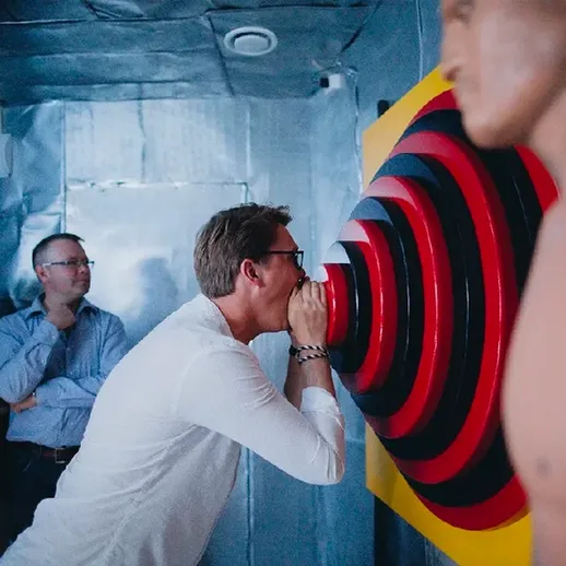 Мужчина разговаривает с фигурой человека в интерактивном музее в вечернее время