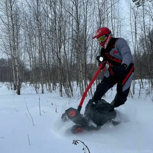 Катание на снегоходе в зимнем лесу при ясной погоде