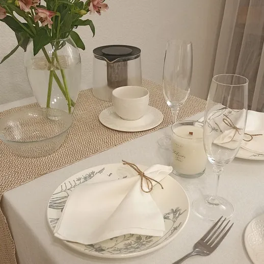 Стол для романтического ужина с элегантной сервировкой и цветами в вазе