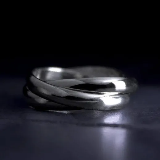 Красивое серебряное кольцо с переплетенными элементами на черном фоне