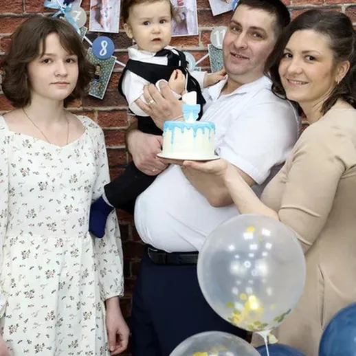 Семейное празднование дня рождения с тортиком и шариками в синем цвете в уютном помещении