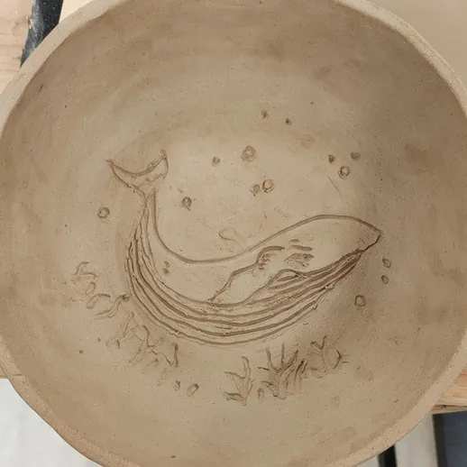 Керамическая чаша с изображением кита и морской жизни, созданная вручную в мастерской в осенний день