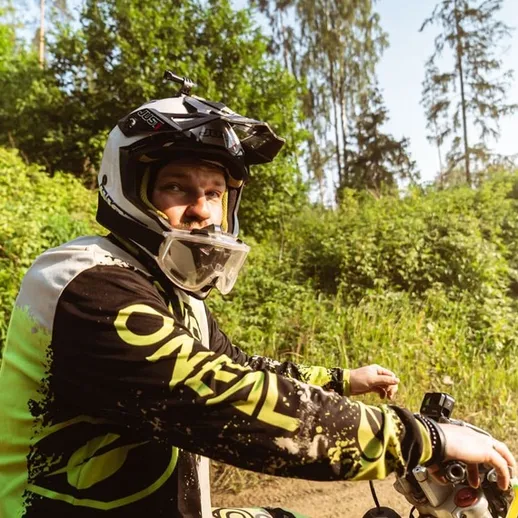 Мотоциклист на лесной тропе в солнечный день наслаждается приключением и природой