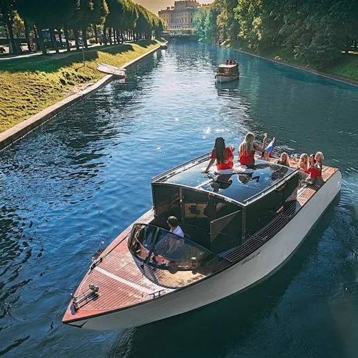 На прогулке по реке с друзьями на пароходе в красивом городском пейзаже в солнечный день