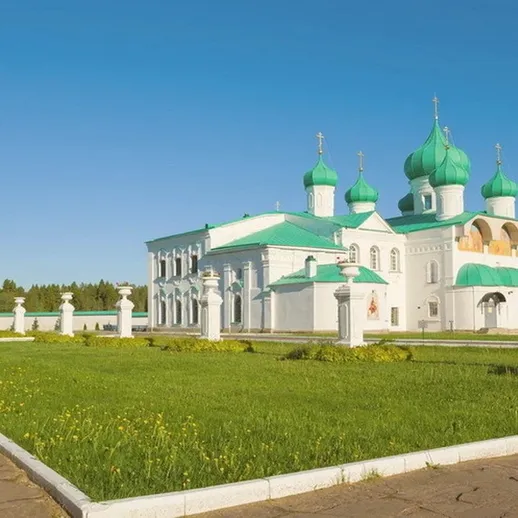 Храм с зелеными куполами и белыми стенами на ясном небе в спокойном уголке природы