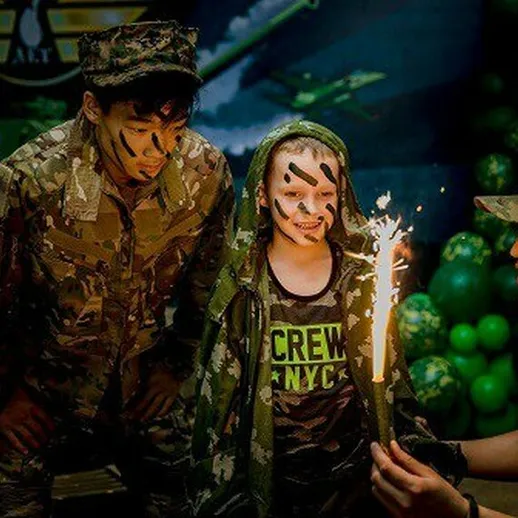 Дети в военной форме с огнем фейерверка на тематическом празднике в лагере