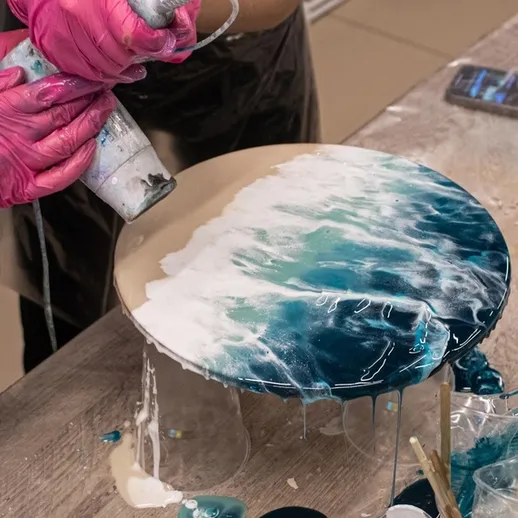 Процесс создания акриловой заливной работы с использованием синих и белых оттенков на деревянной поверхности