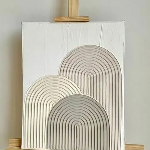 Современное декоративное искусство с рельефом в виде арок на белом фоне, выставленное на мольберте