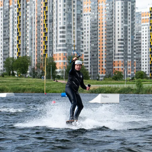Кайтсерфинг на фоне современных жилых зданий в мегаполисе во время теплого дня