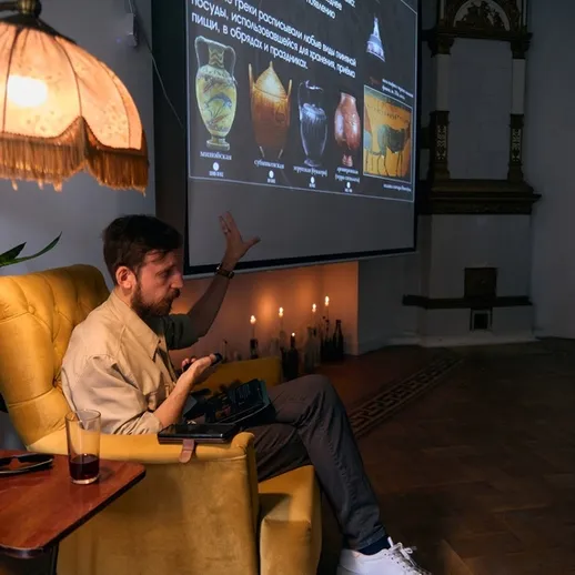 Участник обсуждения рассказывает о древних артефактах во время лекции в уютном помещении