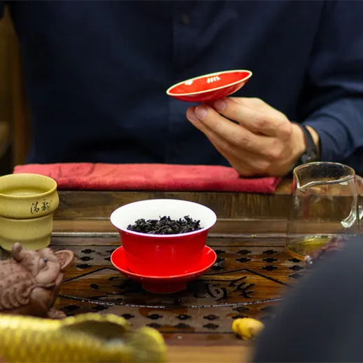 Чайная церемония в традиционном китайском стиле с использованием красной посуды в уютном помещении