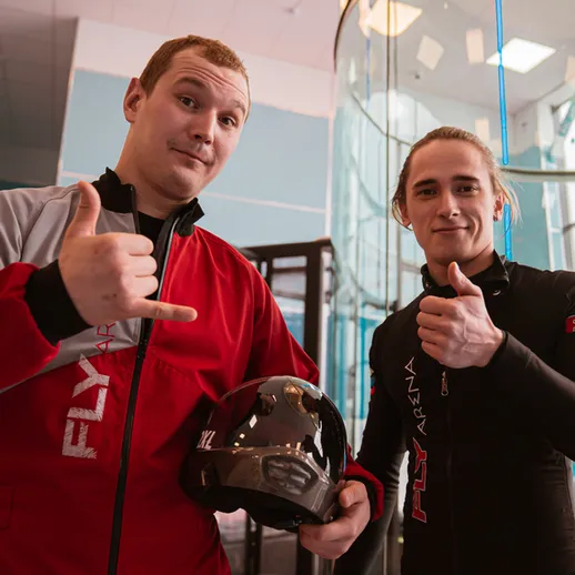 Два человека в спортивной одежде перед полетом в аэродинамической трубе в развлекательном центре