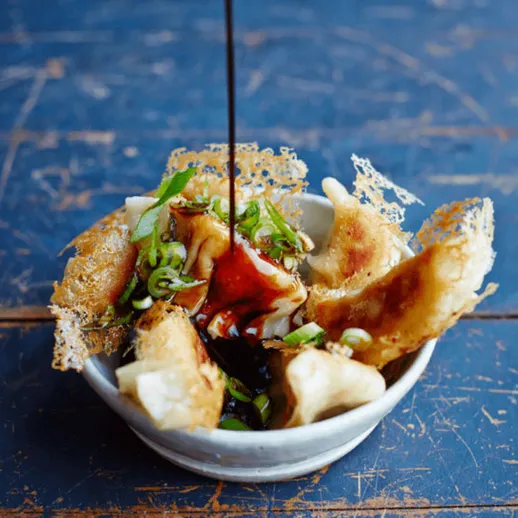 Пельмени с соусом на синем столе в ресторане, вкусный обед или закуска в уютной атмосфере