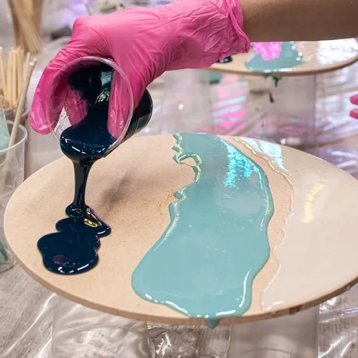 Процесс создания художественной resin-работы с использованием синей и голубой эпоксидной смолы на деревянной поверхности