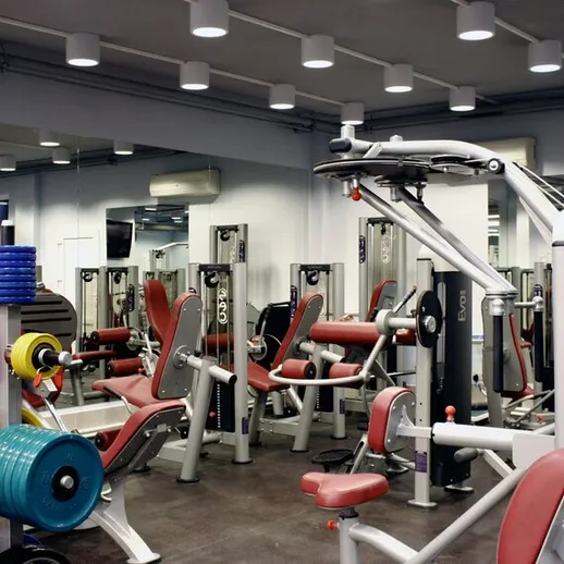 Современный тренажерный зал с разнообразным оборудованием для фитнеса и силовых тренировок