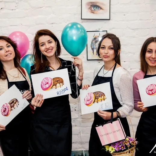 Четыре девушки с рисунками на мастер-классе по живописи в студии в центре города