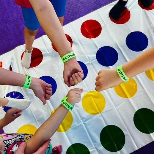 Дети играют в твистер на ярком поле в дружеской атмосфере в летнем лагере в России