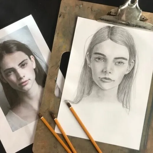 Эскиз портрета девушки на бумаге с референсом рядом