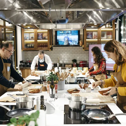 Групповое занятие по кулинарии в современном кулинарном классе в городе, где участники готовят разнообразные блюда