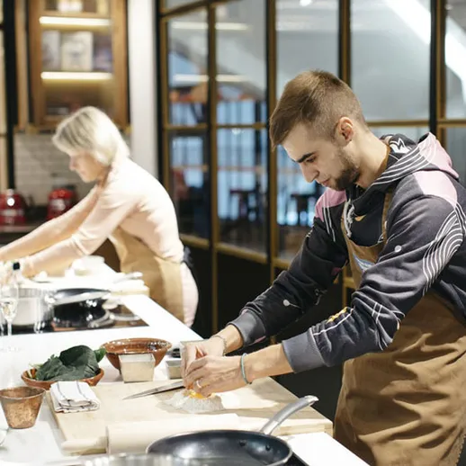 Кулинарный урок в стильной студии: мужчина и женщина готовят блюда на кухне с современным дизайном